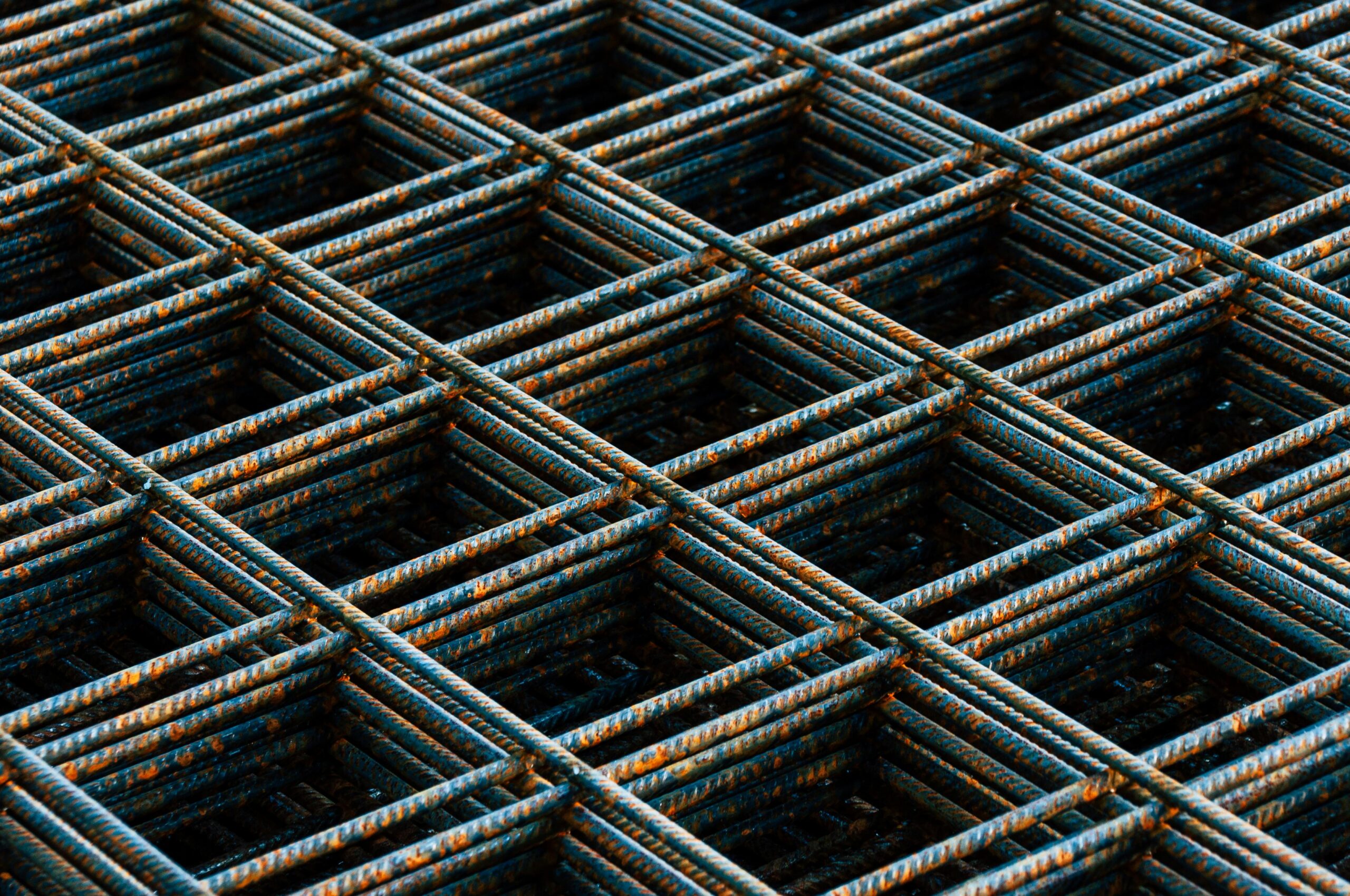 Detailed view of a rusty rebar grid used in construction work, showing texture and pattern.